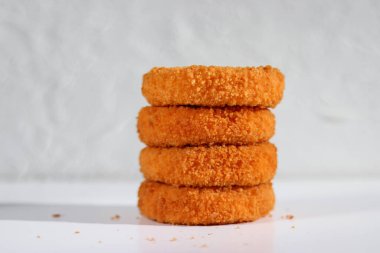 Beyaz arka planda bir yığın kızarmış camembert..