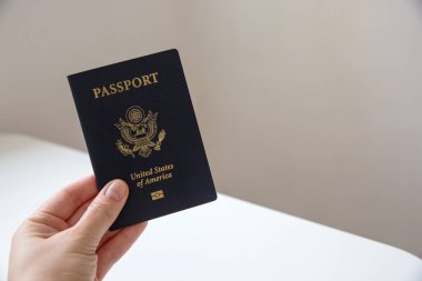 Amerikan pasaportlu, bulanık fotokopi arkaplanı olan bir kadın eli. 
