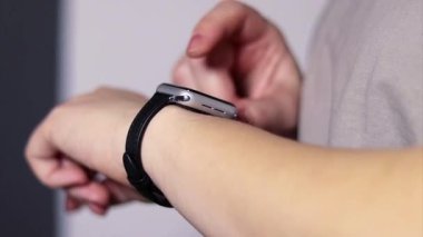 Akıllı ayaklarını bileklerinde kullanan bir kadının yakın plan fotoğrafı, bulanık arka plan. 