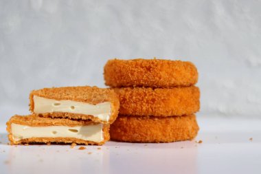 Beyaz masa arkasında bir peynirli kızarmış camembert yığını. 