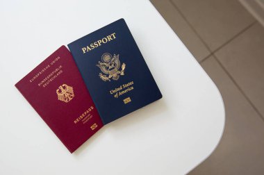 Amerikan ve Alman pasaportlarını beyaz masa arkasında polislerin olduğu yere yakın tut.