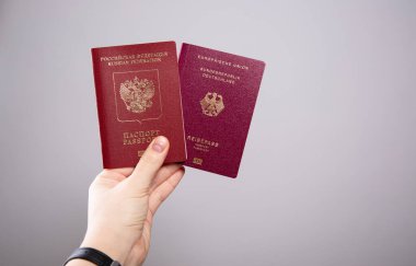 Bir kadının elinde Alman ve Rus pasaportu, boş bir fotokopi alanı.