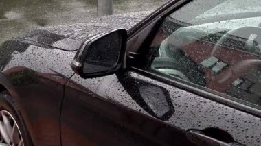 Yağmur damlaları olan siyah bir arabanın yan aynasını kapat. Yüksek kaliteli FullHD görüntüler