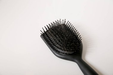 Beyaz masanın üzerinde saç dolu siyah, kirli bir saç fırçasının kapağını kapat, saç dökülme problemi kavramı.