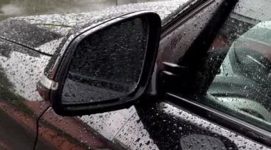 Yağmur damlaları olan siyah bir arabanın yan aynasını kapat. Yüksek kaliteli FullHD görüntüler