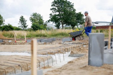 İnşaat alanında duran bir inşaat işçisi. Aile evi yapma kavramı.