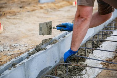 Duvarda çimento harcı yapan tuğla ustası bir işçiye yakın plan bulanık. İnşaat alanı kavramı 