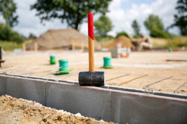 Beton kaldırım taşlarının üzerinde duran plastik bir çekiç yakın çekim, arka planda bulanık zeka inşaat işçileri gündüz vakti 