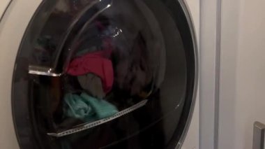 Çamaşır makinesinin kapısını, içinde dönen bezlerle kapat.. 