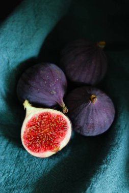 Taze incir meyvelerini koyu gölgeli yeşil kumaşla kaplayın..