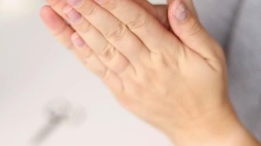 Parmak ve tırnaklara el kremi nemlendirici sürerken kadın ellerini kapat. Sağlıklı tırnaklar ve evde doğal manikür. 