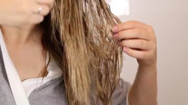 Islak sarı saçları siyah tarak, sağlıklı saç ve saç bakım konseptiyle tarayan bir kadın. Yüksek kaliteli FullHD görüntüler