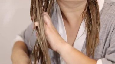 Islak sarı saçları bei, sağlıklı saç ve saç bakımı konseptiyle tarayan bir kadın. Yüksek kaliteli FullHD görüntüler