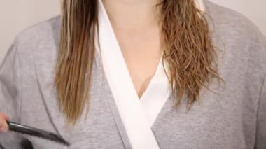 Islak sarı saçları siyah tarak, sağlıklı saç ve saç bakım konseptiyle tarayan bir kadın. Yüksek kaliteli FullHD görüntüler