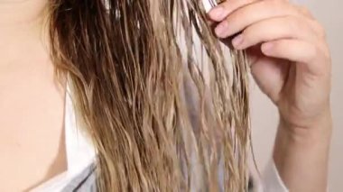 Islak sarı saçları siyah tarak, sağlıklı saç ve saç bakım konseptiyle tarayan bir kadın. Yüksek kaliteli FullHD görüntüler