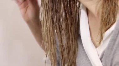 Islak sarı saçları siyah tarak, sağlıklı saç ve saç bakım konseptiyle tarayan bir kadın. Yüksek kaliteli FullHD görüntüler