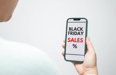 Arkaya bakın, elinde akıllı telefon olan bir kadın Kara Cuma indirimini ekranda gösteriyor. Beyaz kopyalama alanı arkaplanı