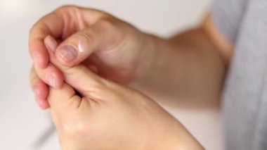 Parmak ve tırnaklara el kremi nemlendirici sürerken kadın ellerini kapat. Sağlıklı tırnaklar ve evde doğal manikür. 