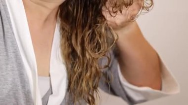 Kadın ellerinin sarı saçlarına kıvırcık kıvırcık saç metodu uygulamasını kapat. Yüksek kaliteli FullHD görüntüler