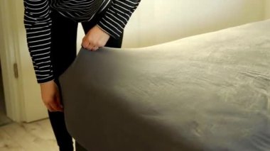 Yatak odasındaki çarşafları değiştiren kadın ellerini kapat. Ev konseptinde haftalık ev işleri 