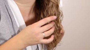 Kadın ellerinin sarı saçlarına kıvırcık kıvırcık saç metodu uygulamasını kapat. Yüksek kaliteli FullHD görüntüler