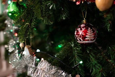 Noel ağacına asılı kırmızı bir süs topunun kapağı, şenlikli arka plan 