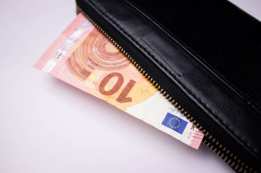 Siyah deri cüzdan, beyaz masa arkasında 10 euro banknotlar.
