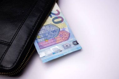 Siyah deri cüzdan, beyaz masa arkasında 20 euro banknotlar.
