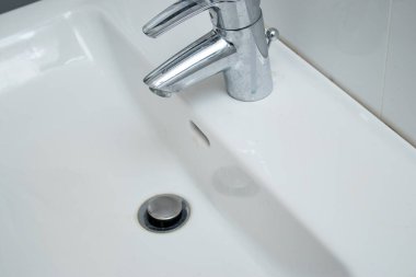 Kireçtaşı lekeli ve kirli beyaz lavabolu banyo musluğunu kapat. Ev işleri konsepti 