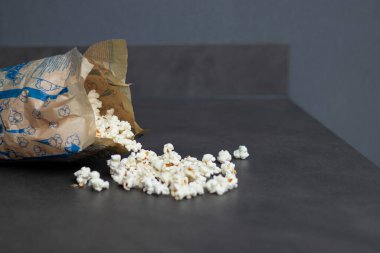 Gri mutfak masasında mikrodalgada pişirilmiş taze patlamış mısır. Ev konseptinde atıştırmalıklar 