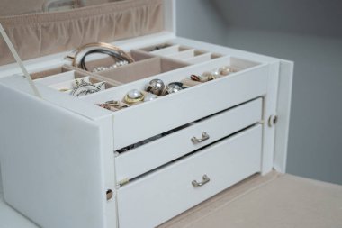 Farklı bijouterie 'leri beyaz deri bir mücevher kutusunda kapat. Zarif kadın aksesuarları koleksiyonu 