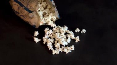 Gri mutfak masasında mikrodalgada yapılan kağıt torbada taze patlamış mısır. Ev konseptinde atıştırmalıklar 