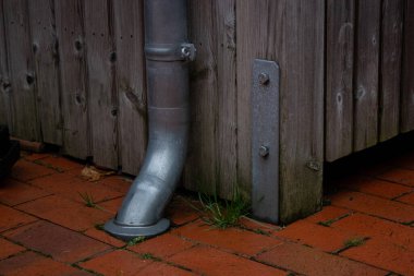 Yağmur oluğu borularının kapatıldığı toprak, ahşap eski bir ev. Oluk sistemi kavramı 