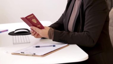 Ofis masasında Rus pasaportu olan beyaz bir kadının vize başvuru formlarını doldurması. Yüksek kaliteli FullHD görüntüler