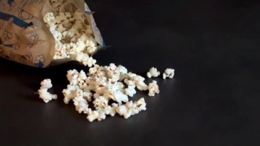 Gri mutfak masasında mikrodalgada yapılan kağıt torbada taze patlamış mısır. Ev konseptinde atıştırmalıklar 