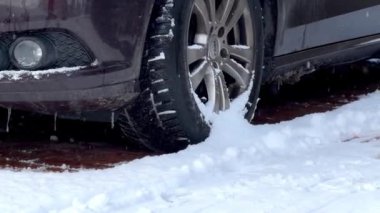 Kışın karla kaplı bir yolda arabanın lastiğini kapat. Soğuk sezon konsepti 