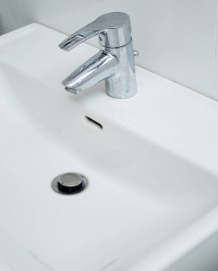 Kireçtaşı lekeli ve kirli beyaz lavabolu banyo musluğunu kapat. Ev işleri konsepti 