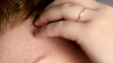 Kafasına serum uygulayan beyaz bir şişeyle sarı saçlı bir kadının fotoğrafını çek. Yüksek kaliteli FullHD görüntüler