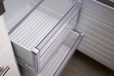 Temizlenmesi gereken, içinde yiyecek olmayan açık ve kirli bir buzdolabı rafını kapat. Ev konseptinde hijyen ve temiz mutfak. 