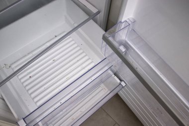 Temizlenmesi gereken, içinde yiyecek olmayan açık ve kirli bir buzdolabı rafını kapat. Ev konseptinde hijyen ve temiz mutfak. 