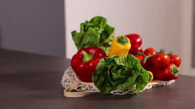 Taze mevsimlik sebzeleri gri mutfak masasındaki bir alışveriş çantasında kapatıyoruz. Sıfır atık ve çevre dostu market alışveriş konsepti. Yüksek kaliteli FullHD görüntüler