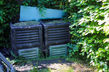 Bahçe atığı gübre kutusu, yeşil çim biçme makinesi, yazın bahçede.