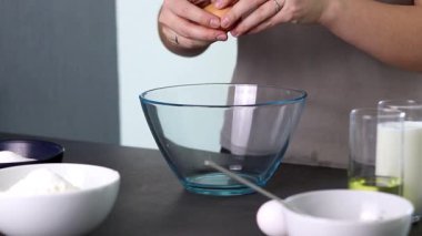 Mutfakta çiğ yumurtaları cam kaseye kıran bir dişinin fotoğrafını çek. Hamuru pişirmek için hazırlıyorum. Yüksek kaliteli FullHD görüntüler