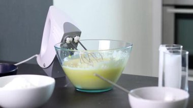 Cam kasedeki malzemeleri el çırpma makinesiyle karıştırıp evde kek hamuru ve mutfak masası hazırlamak. Yüksek kaliteli FullHD görüntüler