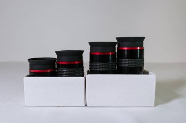 Siyah teleskop, beyaz arka planda beyaz bir kutunun içindeki göz kapakları. Optik lensler - astronomik teleskop için aksesuar