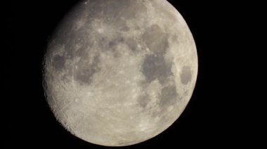 Moon moves in the frame close-up. View through a telescope. Meteor craters on the surface of the Moon, dark sky background