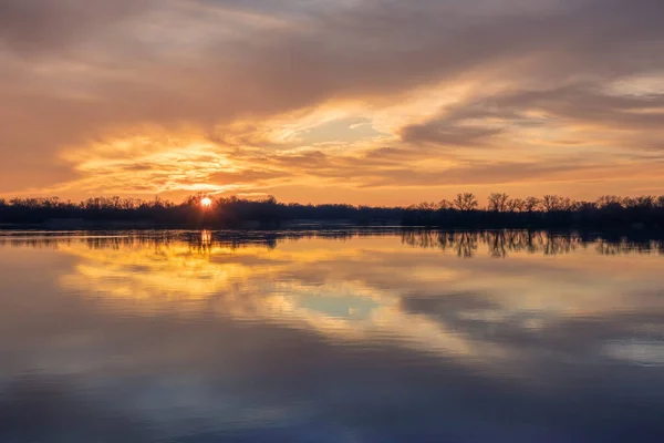 stock image Beautiful sunset with reflection of clouds on the surface of the smooth water of a wide river