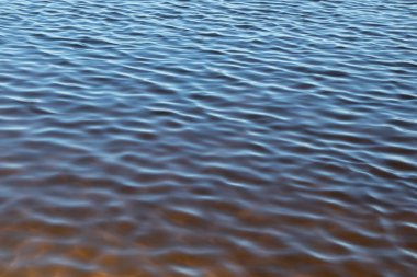 Dalgalı, üst manzaralı, doğal arka planlı güzel mavi su yüzeyi.