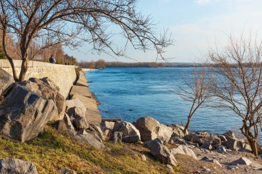 Ukrayna 'nın Kremenchuk şehrindeki Dinyeper Nehri' nin seti. Geniş bir nehrin resimli kıyısı, taş ve beton bloklarla güçlendirilmiş. Güneşli bir gün