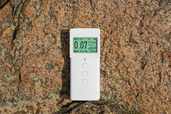 Measurement of radiation from granite stone. Modern device dosimeter radiometer lies on the surface of the stone. Metering of the level of ionizing radiation